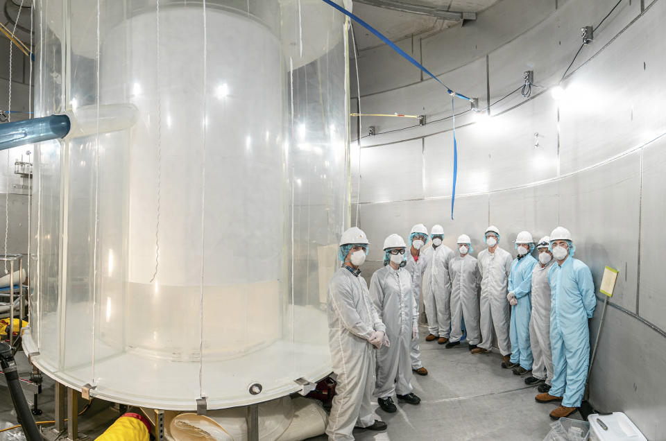 This photo provided by Sanford Underground Research Facility shows members of the LZ team in the LZ water tank after the outer detector installation in Lead, S.D. Scientists have begun a new search for mysterious dark matter in a former gold mine a mile underground. Dark matter makes up the vast majority of the mass of the universe but scientists don't know what it is. (Matthew Kapust/Sanford Underground Research Facility via AP)