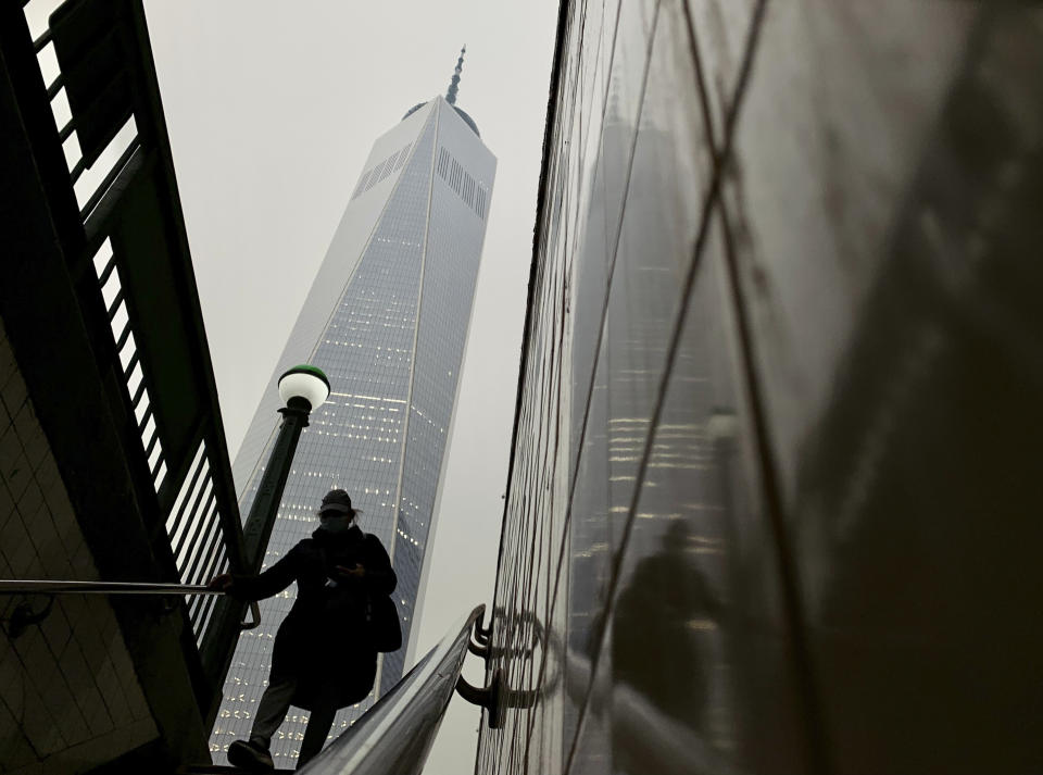 A commuter steps into the subway as smoke from wildfires in Canada partially obscure One World Trade Center in lower Manhattan, Tuesday, June 6, 2023, in New York. (AP Photo/Daniel P. Derella)