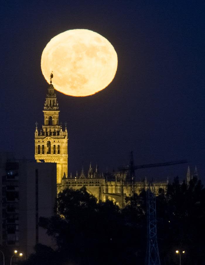 Salida de la luna ante la Giralda de Sevilla, España. (EFE)