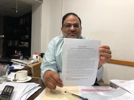 Salim Ud Din, a spokesman for the Ahmadi community, holds up an advertisement outlining during an interview with Reuters in the town of Rabwah, Pakistan July 9, 2018. Picture taken July 9, 2018. REUTERS/Saad Sayeed