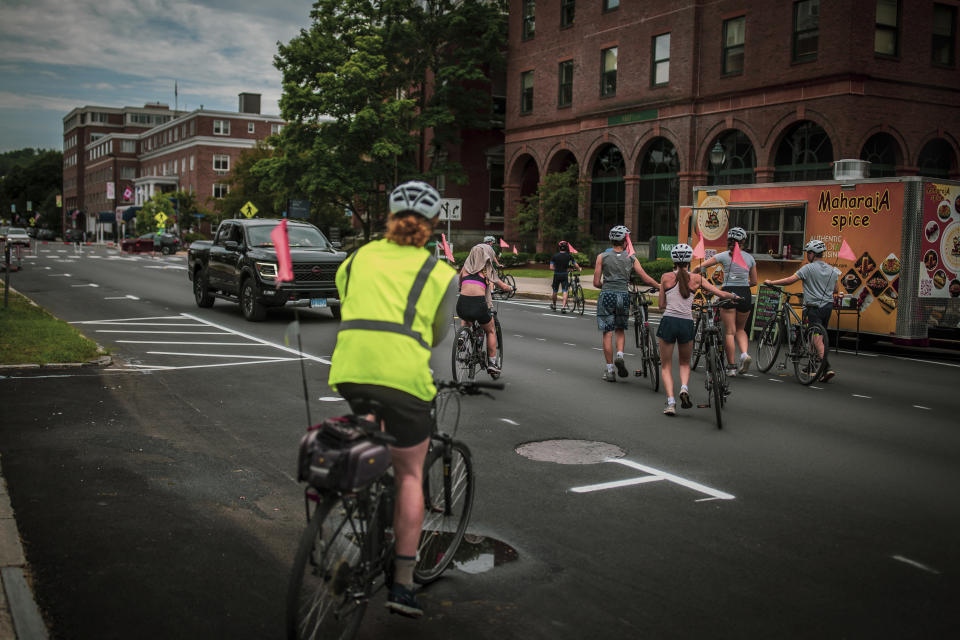 Montpelier residents ride their bikes on State street which was one one of the most damaged parts of the state's capital in result of 2023 flood, July 3, 2024. A year after catastrophic flooding inundated parts of Vermont, some homeowners are still in the throes of recovery. (AP Photo/ Dmitry Belyakov)