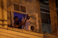 A man bangs a pot at the window of his house as he protests against Brazilian President Jair Bolsonaro during the coronavirus disease (COVID-19) outbreak in Rio de Janeiro