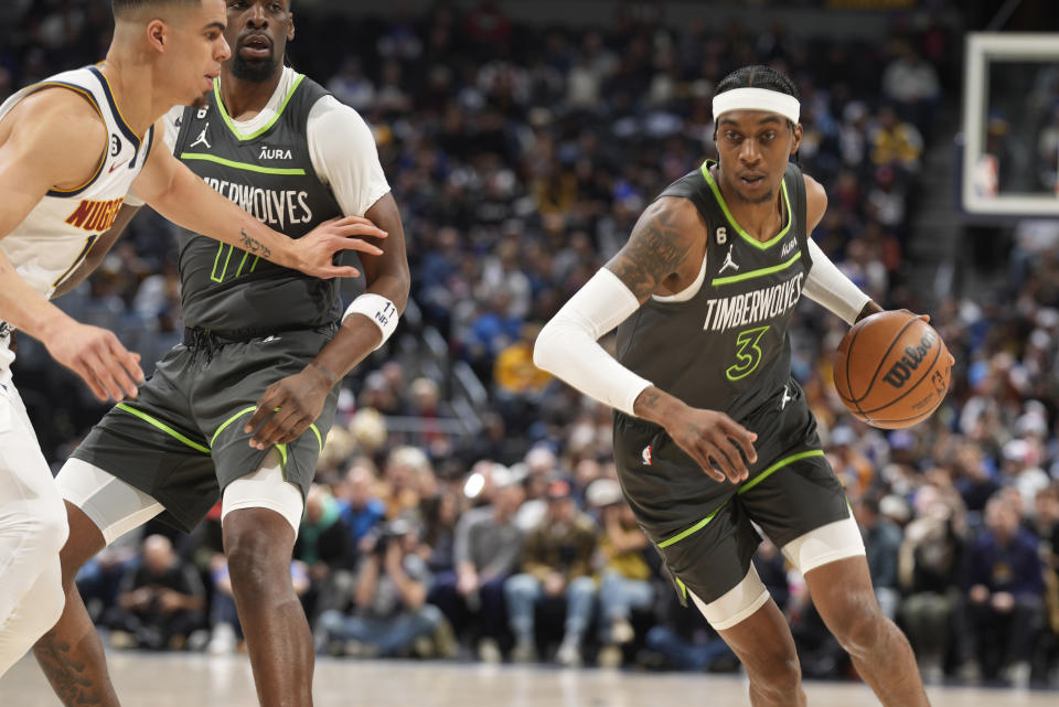 Minnesota Timberwolves forward Jaden McDaniels, right, drives to the rim as Denver Nuggets forward Michael Porter Jr. defends in the first half of an NBA basketball game Wednesday, Jan. 18, 2023, in Denver. (AP Photo/David Zalubowski)