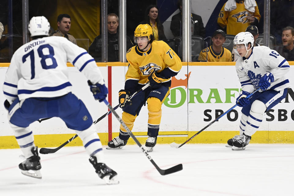 Nashville Predators right wing Luke Evangelista (77) looks to pass the puck as Toronto Maple Leafs defenseman T.J. Brodie (78) and right wing Mitchell Marner (16) defend during the second period of an NHL hockey game Sunday, March 26, 2023, in Nashville, Tenn. (AP Photo/Mark Zaleski)
