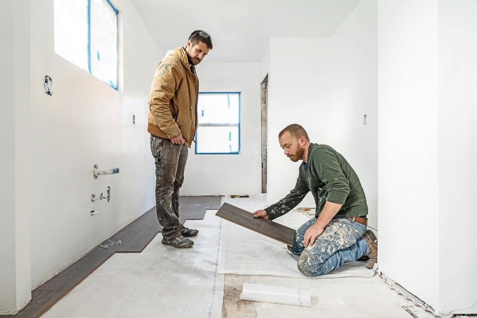 Keith Bynum and Evan Thomas laying flooring in a scene from HGTV's "Bargain Block."