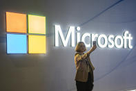 FILE - A visitor takes a photo at the Microsoft stand at Mobile World Congress 2024 in Barcelona, Spain, Feb. 27, 2024. New European Union rules aimed at preventing tech companies from dominating digital markets will change what people see online starting Thursday, March 7, 2024. (AP Photo/Pau Venteo, File)