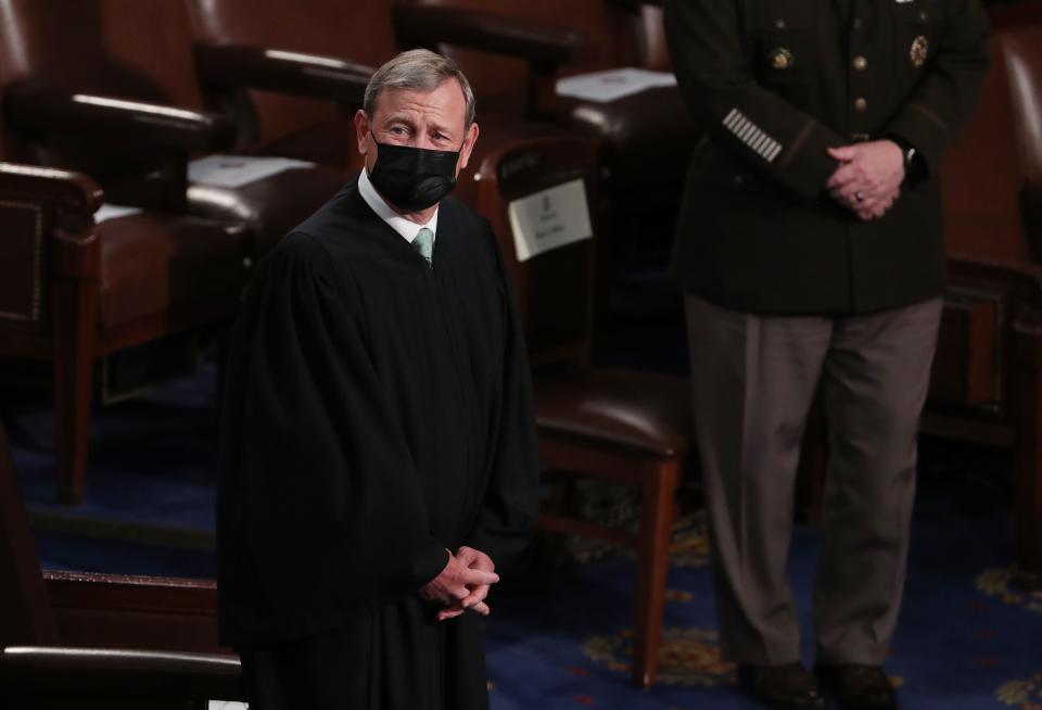 Chief Justice of the US Supreme Court John Roberts wears a black robe and a black face mask.