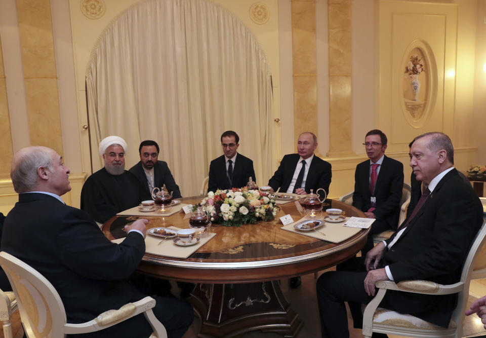 Belarusian President Alexander Lukashenko, left, joins Russian President Vladimir Putin, 3rd right, center, Iranian President Hassan Rouhani, 2nd left and Turkish President Recep Tayyip Erdogan, right, for a dinner following their talks in the Bocharov Ruchei residence in the Black Sea resort of Sochi, Russia, Thursday, Feb. 14, 2019. Putin hosted the leaders of Turkey and Iran for talks about a Syria peace settlement as expectations mount for an imminent and final defeat of the Islamic State group. (Presidential Press Service via AP, Pool)