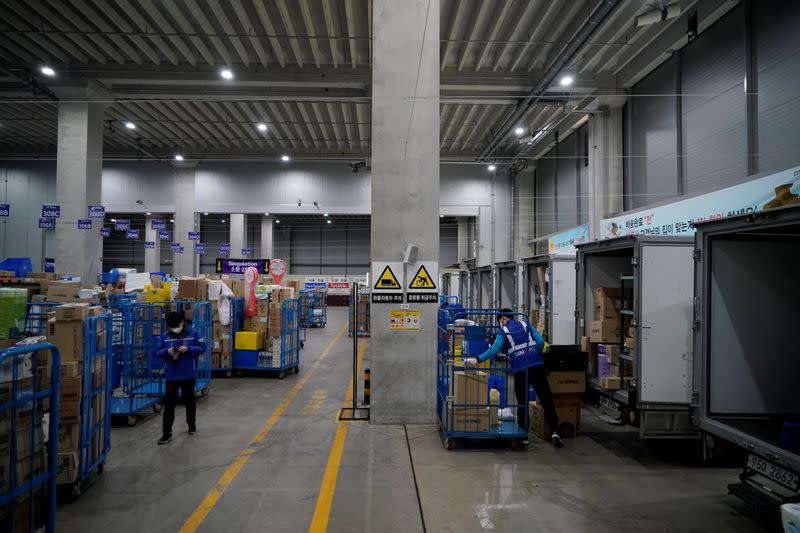 A delivery man for Coupang Jung Im-hong wearing a mask to prevent contracting the coronavirus, loads packages before leaving to deliver them in Incheon