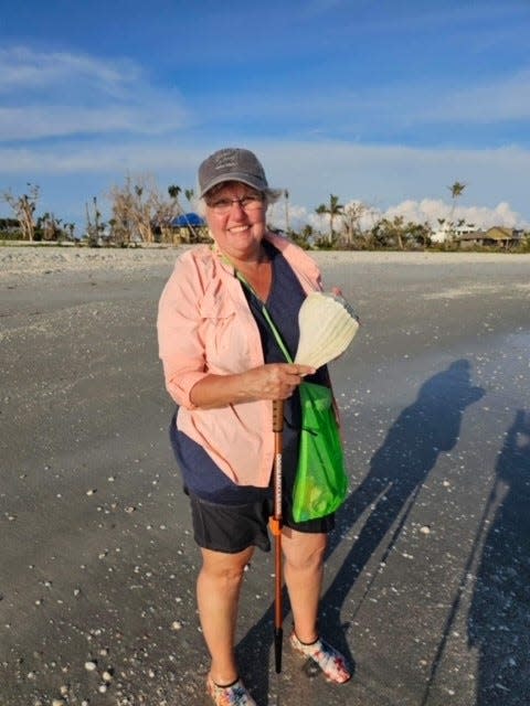 Lyn Bowen-Radcliff holds the whelk shell she found recently on Sanibel for her seashell collection.