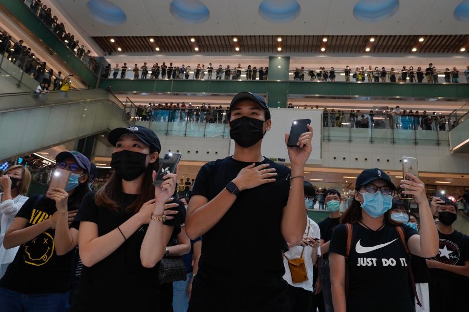 Protestors wearing masks in defiance of a recently imposed ban on face coverings sing "Glory to Hong Kong" at a shopping mall in Hong Kong, Sunday, Oct.13, 2019. The semi-autonomous Chinese city is in its fifth month of a movement that initially began in response to a now-withdrawn extradition bill that would have allowed Hong Kong residents to be tried for crimes in mainland China. The protests have since ballooned to encompass broader demands for electoral reforms and an inquiry into alleged police abuse. (AP Photo/Vincent Yu)