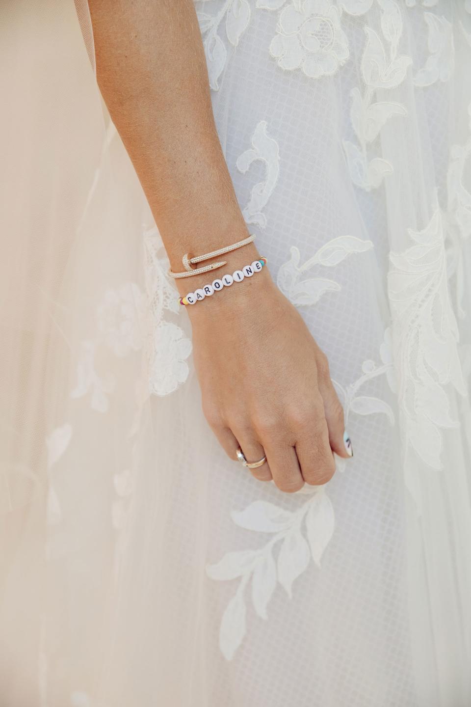 A close-up of the bride’s everyday jewelry against the intricate Lyon lace detailing on her wedding dress.