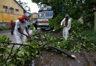 Rescue workers cut tree branches that fell on a truck trailer after heavy winds caused by Cyclone Amphan, in Kolkata, India, May 20, 2020. REUTERS/Rupak De Chowdhuri