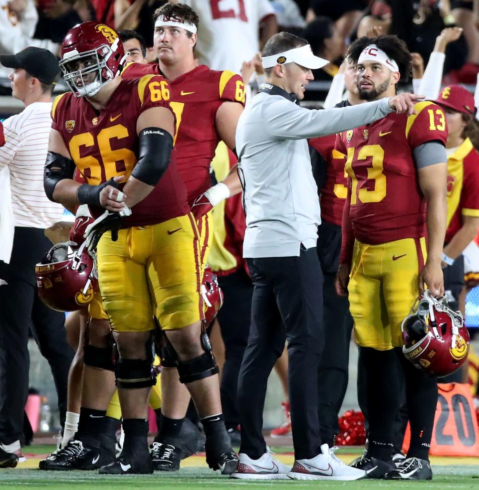 USC coach Lincoln Riley points as he talks on the sideline with quarterback Caleb Williams