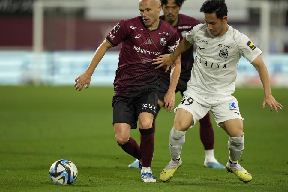 Vissel Kobe midfielder Andres Iniesta, left, vies for the ball with Consadole Sapporo midfielder Supachok Sarachat during the first half of a friendly soccer match in Kobe, Japan, Saturday, July 1, 2023. The 39-year-old Spanish footballer plays his last match for the Japanese club Saturday. (AP Photo/Hiro Komae)