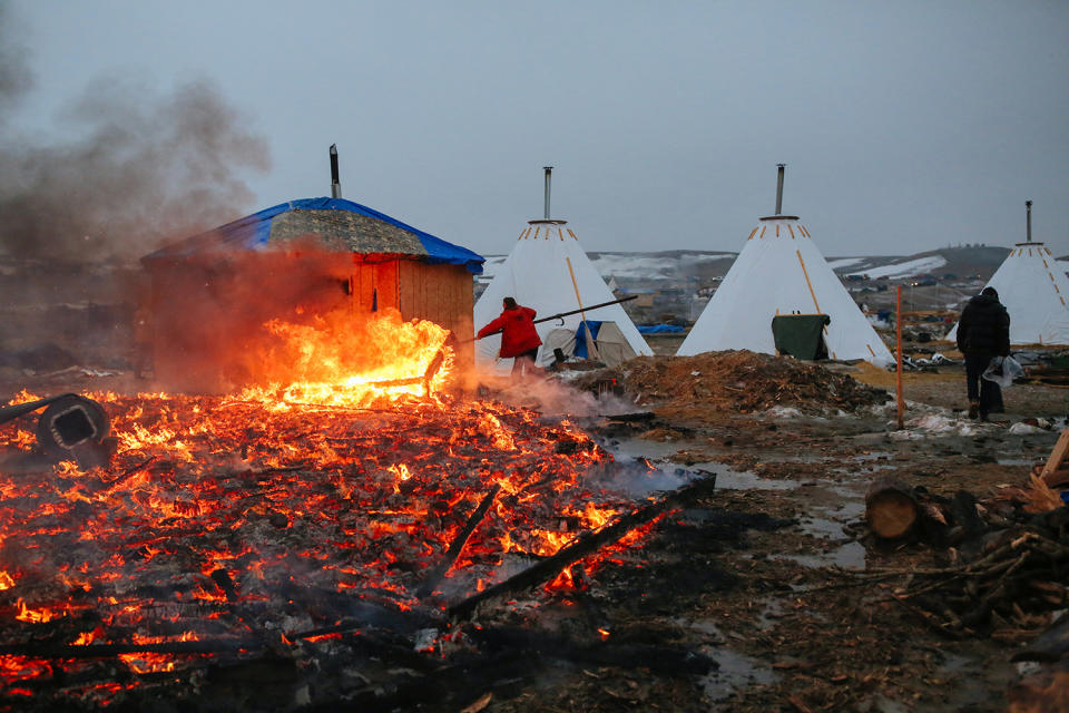 <p>A building burns after it was set on fire by protesters preparing to evacuate the main opposition camp against the Dakota Access oil pipeline, near Cannon Ball, N.D., Feb. 22, 2017. (Photo: Stephen Yang/Getty Images) </p>