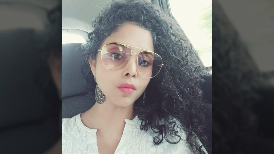 Rana Ayyub sits in a car wearing large sunglasses.