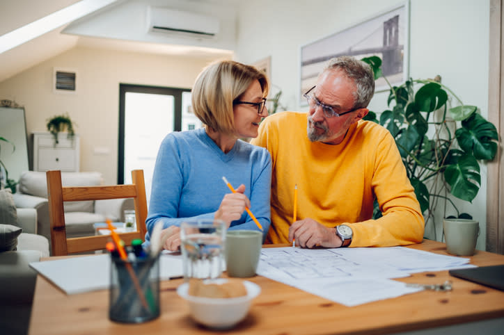 A retired couple looks over plans for a home improvement project.