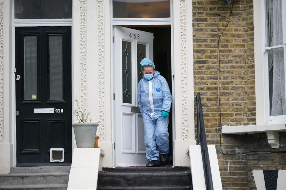 A forensic officer at the property on Montague Road in Dalston (PA)