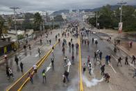 <p>Supporters of Libre Alliance presidential candidate Salvador Nasralla throw rocks at riot police near the National Institute of Professional Training, where election ballots are stored, in Tegucigalpa, Honduras, Thursday, Nov. 30, 2017. (Photo: Rodrigo Abd/AP) </p>