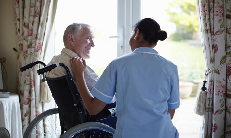 Nurse talking to older man in home