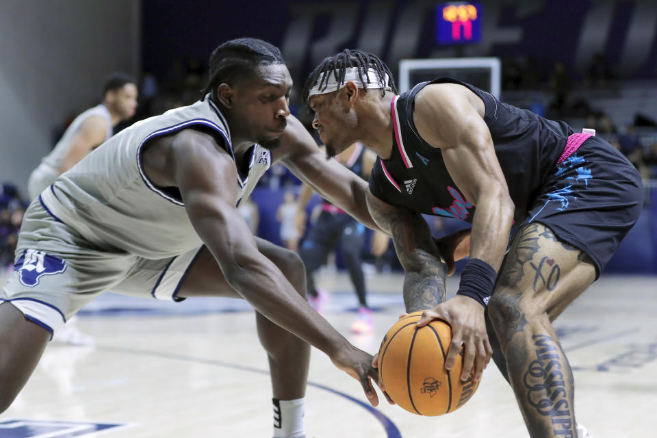 Rice forward Sam Alajiki, left, reaches in as Florida Atlantic guard Alijah Martin, right, looks to drive around during the first half of an NCAA college basketball game Wednesday, Jan. 24, 2024, in Houston. (AP Photo/Michael Wyke)