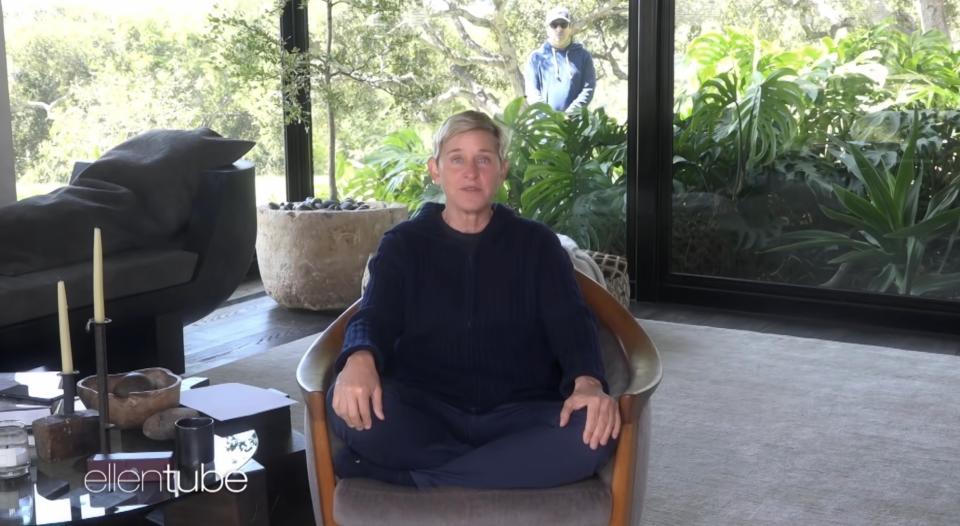 ellen sitting cross-legged in a chair at home