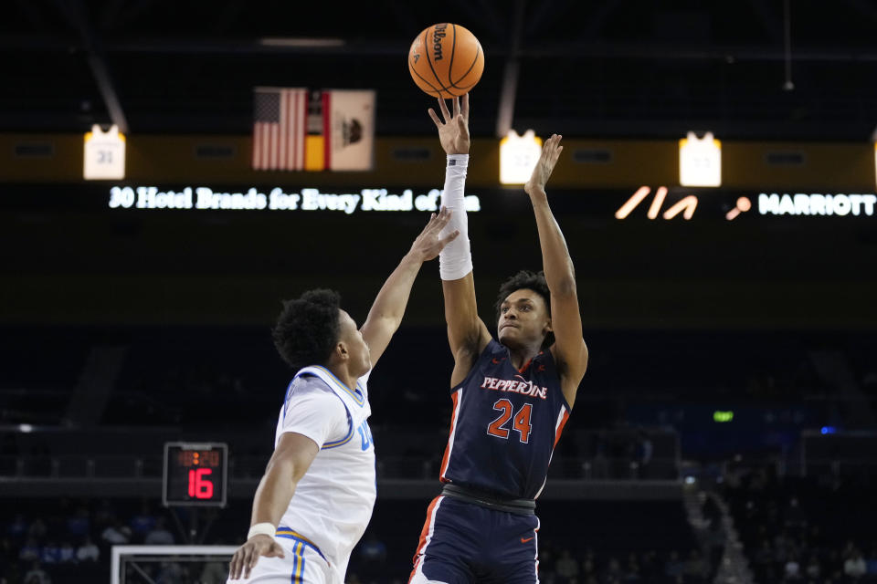 Pepperdine forward Maxwell Lewis (24) shoots over UCLA guard Jaylen Clark during the first half of an NCAA college basketball game Wednesday, Nov. 23, 2022, in Los Angeles. (AP Photo/Marcio Jose Sanchez)