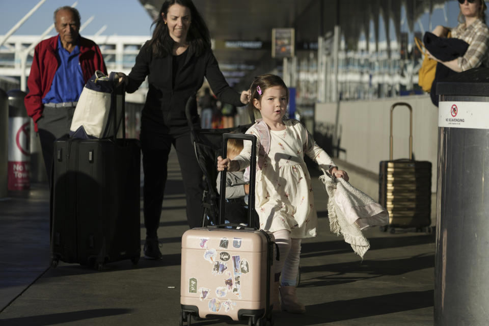 Passengers carry their own luggage during the busy week of Thanksgiving, Wednesday, Nov. 22, 2023, at Los Angeles International Airport in Los Angeles. The late crush of holiday travelers is picking up steam, with about 2.7 million people expected to board flights on Wednesday and millions more planning to drive or take the train to Thanksgiving celebrations. (AP Photo/Damian Dovarganes)