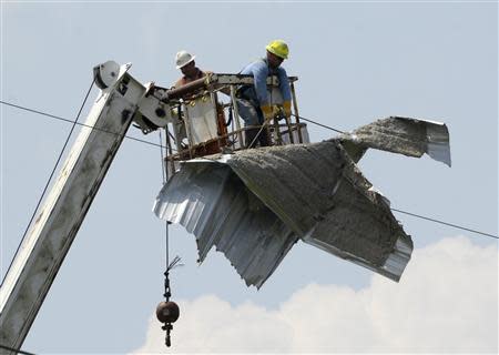 Power line technician remove tornado debris from power lines after a tornado hit Pearl, Mississippi April 29, 2014. REUTERS/Gene Blevins