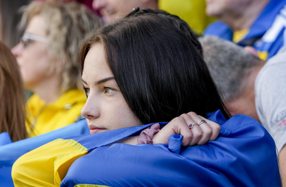 A young woman watches players of Ukraine's national soccer team during a public training session in Wiesbaden, Germany, Thursday, June 13, 2024, ahead of their group E match against Romania at the Euro 2024 soccer tournament. (AP Photo/Michael Probst)