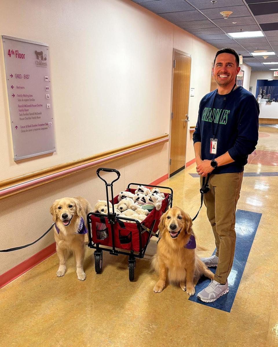 PHOTO: Kevin Bubolz, founder of Golden Retriever Life, with therapy dogs Ellie and Emma and a wagon of plush golden retriever toys. (Courtesy of @EllieGoldenLife)