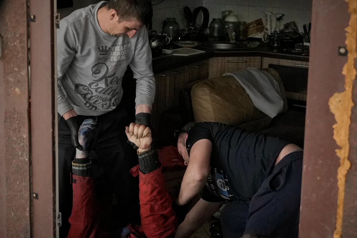 Municipal workers remove the body of a man in a house in Bucha, Ukraine (Copyright 2022 The Associated Press. All rights reserved.)