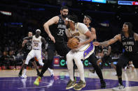 Los Angeles Lakers forward Anthony Davis (3) is defended by Orlando Magic's Goga Bitadze, left, and Markelle Fultz (20) during the first half of an NBA basketball game Sunday, March 19, 2023, in Los Angeles. (AP Photo/Marcio Jose Sanchez)