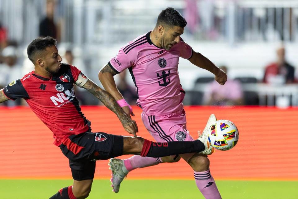 El delantero del Inter Miami Luis Suárez (der.) conduce el balón ante la marca del defensa de Newell’s Old Boys Leonel Vangioni, en el partido celebrado el 15 de febrero de 2024 en Fort Lauderdale, Florida.