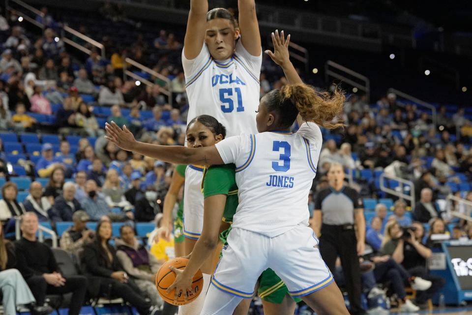 Oregon guard Kennedi Williams, bottom left, is double-teamed by UCLA center Lauren Betts (51) and guard Londynn Jones (3) during the first half of the game in Los Angeles, Friday, Jan. 5, 2024.