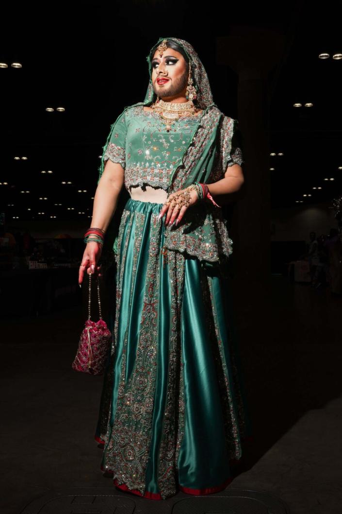 A person poses in an embellished emerald outfit.