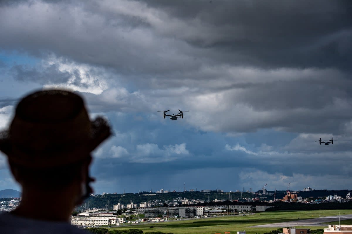 MV-22 Osprey tilt-rotor aircraft in flight after taking off from US Marine Corps Air Station Futenma, as a person looks on towards the military base from Kakazutakadai Park in the city of Ginowan, Okinawa prefecture (AFP via Getty Images)