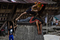 NIAS ISLAND, INDONESIA - FEBRUARY 24: A villager wearing traditional costume jumps over a stone in front of their ancient houses in Orahili Fau village on February 24, 2013 in Nias Island, Indonesia. Stone Jumping is a traditional ritual, with locals leaping over large stone towers, which in the past resulted in serious injury and death. Stone jumping in Nias Island was originally a tradition born of the habit of inter tribal fighting on the island of Nias. (Photo by Ulet Ifansasti/Getty Images)