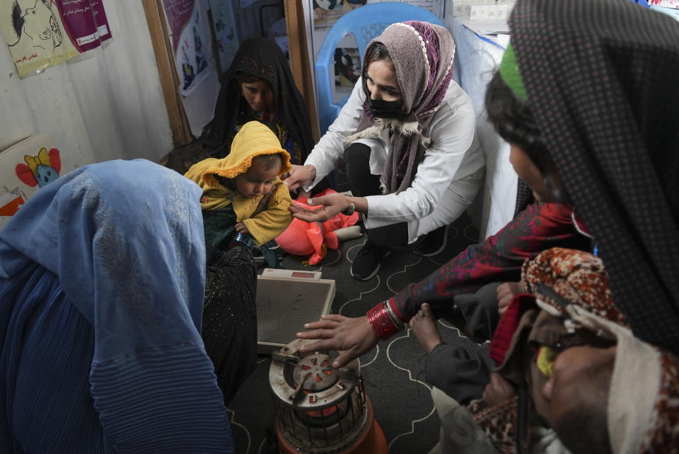 FILE - A nurse checks the weight of a child in the makeshift clinic organized by World Vision at a settlement near Herat, Afghanistan, on Dec. 16, 2021. (AP Photo/Mstyslav Chernov, File)