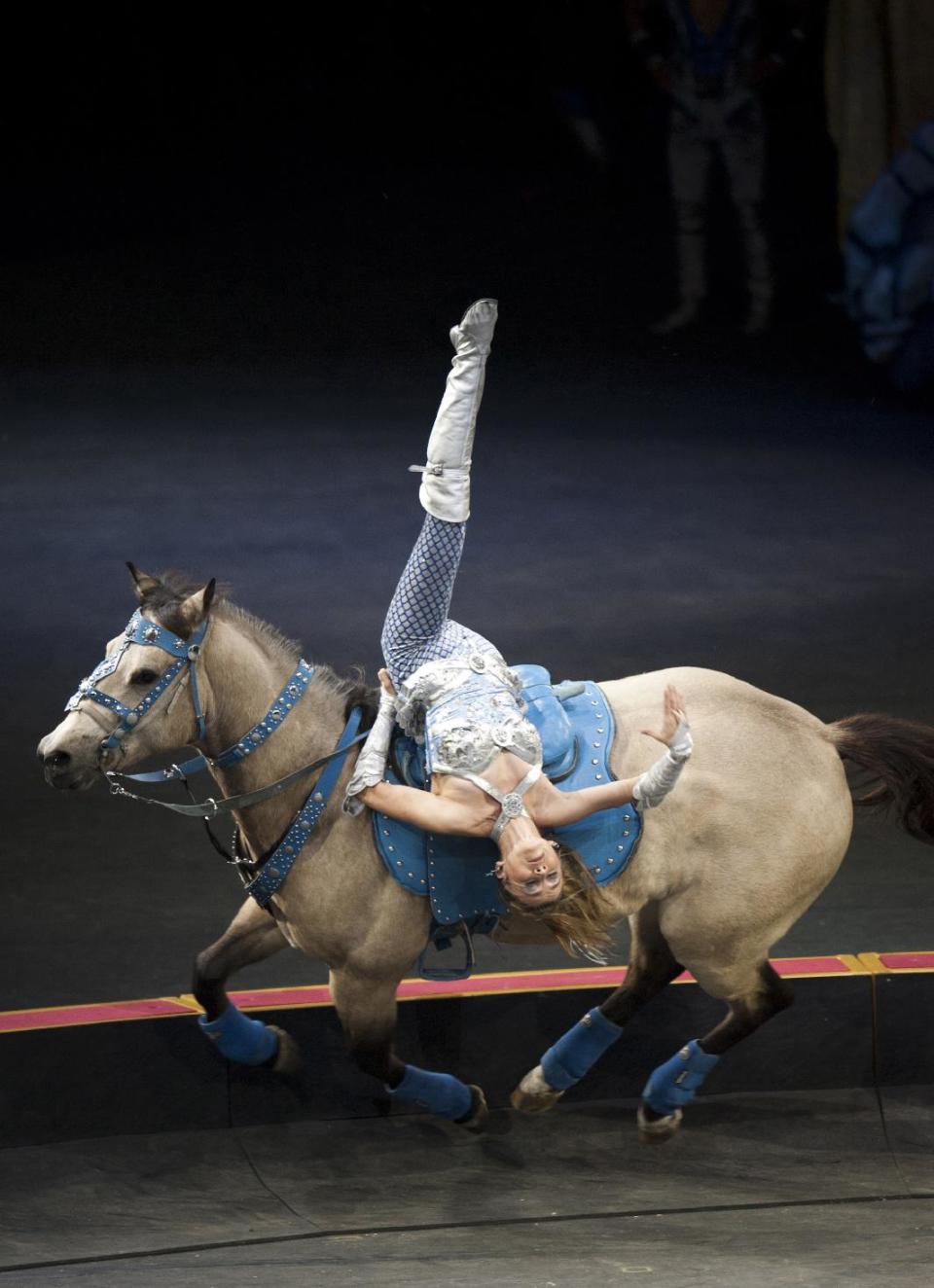 In this January 2012 photo provided by Feld Entertainment, producers of Ringling Bros. and Barnum & Bailey, Tatiana of the Cossack riders performs acrobat maneuvers during Ringling Bros. Presents "Dragons" show launched in Tampa, Fla. Over the years, the Feld family has made changes that have alienated some traditionalists, such as eliminating the three-ring format. But sisters Nicole and Alana Feld, who produce the circus, say they try to walk a tightrope between innovating and maintaining traditions. (AP Photo/Feld Entertainment, Heinz Kluetmeier)