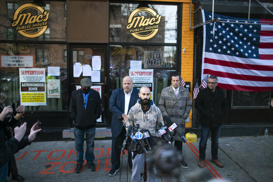 Danny Presti, center, a co-owner of Mac's Public House, speaks during a press conference outside the closed bar that was defying coronavirus restrictions on Staten Island Monday, Dec 7, 2020, in New York. Authorities in New York City said Presti was arrested early Sunday, Dec. 6 after running over a deputy with his car. (AP Photo/Eduardo Munoz Alvarez)