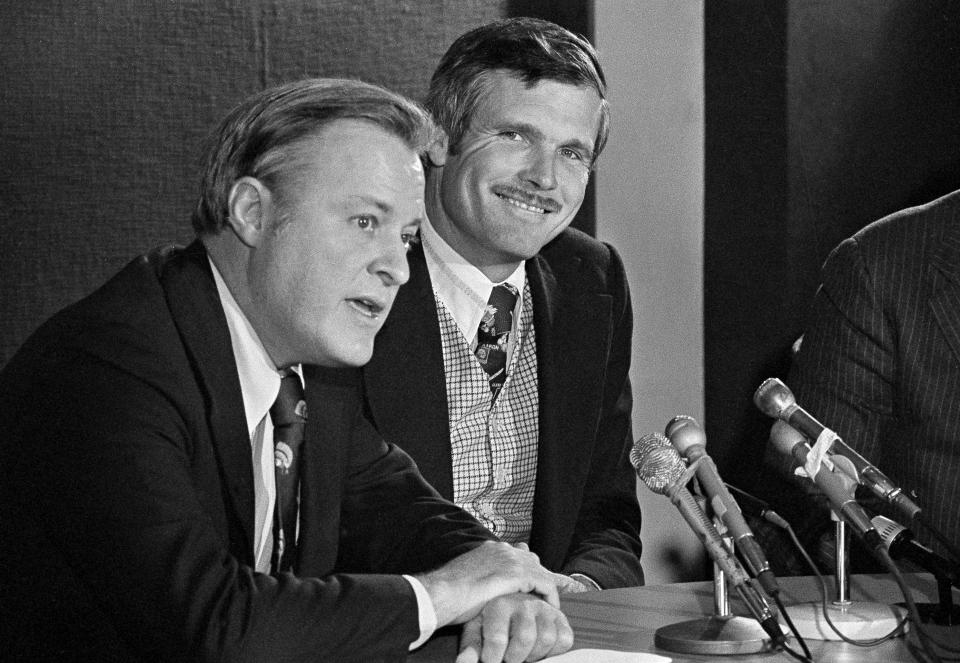 FILE - In this Jan. 7, 1976, file photo, Atlanta Braves chairman Bill Bartholomay, left, and Atlantan Ted Turner, talk with newsmen after it was announced that Turner had purchased the Braves from the Atlanta-LaSalle Corporation in Atlanta. Bartholomay, the former Braves owner who moved the team from Milwaukee to Atlanta in 1966, died Wednesday, March 25, 2020, at New York-Presbyterian Hospital, according to his daughter, Jamie. He was 91. Bartholomay sold the Braves to Ted Turner in 1976 but remained as chairman of the team's board of directors until 2003, when he assumed an emeritus role.(AP Photo/Charles E. Kelly, File)