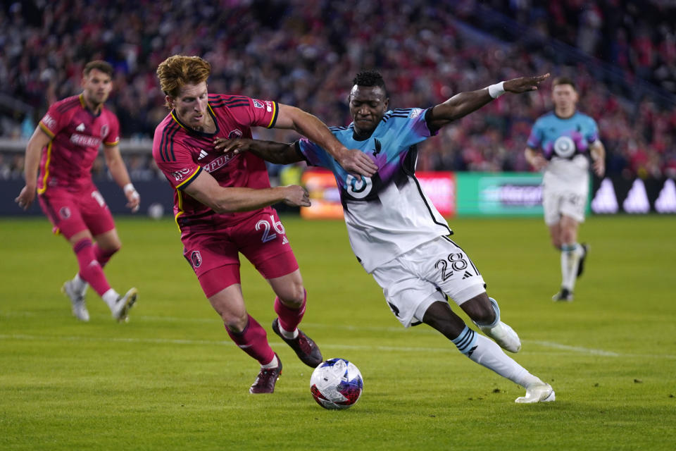 Minnesota United's Mender Garcia (28) and St. Louis City's Tim Parker (26) battle for the ball during the first half of an MLS soccer match Saturday, April 1, 2023, in St. Louis. (AP Photo/Jeff Roberson)