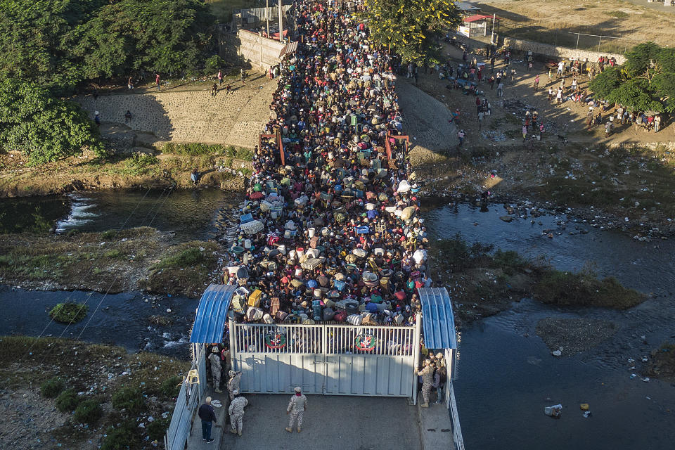 Haitians wait to cross the border between Dominican Republic and Haiti in Dajabon, Dominican Republic, Friday, Nov. 19, 2021. As the rest of the world closes its doors to Haitian migrants, the country that shares an island with Haiti also is cracking down in a way that human rights activists say hasn’t been seen in decades. (AP Photo/Matias Delacroix)