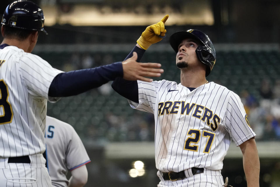 Milwaukee Brewers' Willy Adames, right, gestures after hitting an RBI single during the 10th inning of a baseball game against the Miami Marlins Sunday, Oct. 2, 2022, in Milwaukee. (AP Photo/Aaron Gash)