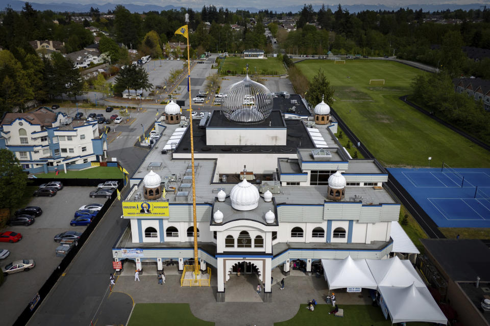 In this photograph taken with a drone, people sit on the front lawn of the Guru Nanak Sikh Gurdwara, in Surrey, B.C. on Friday, May 3, 2024. (Ethan Cairns/The Canadian Press via AP)