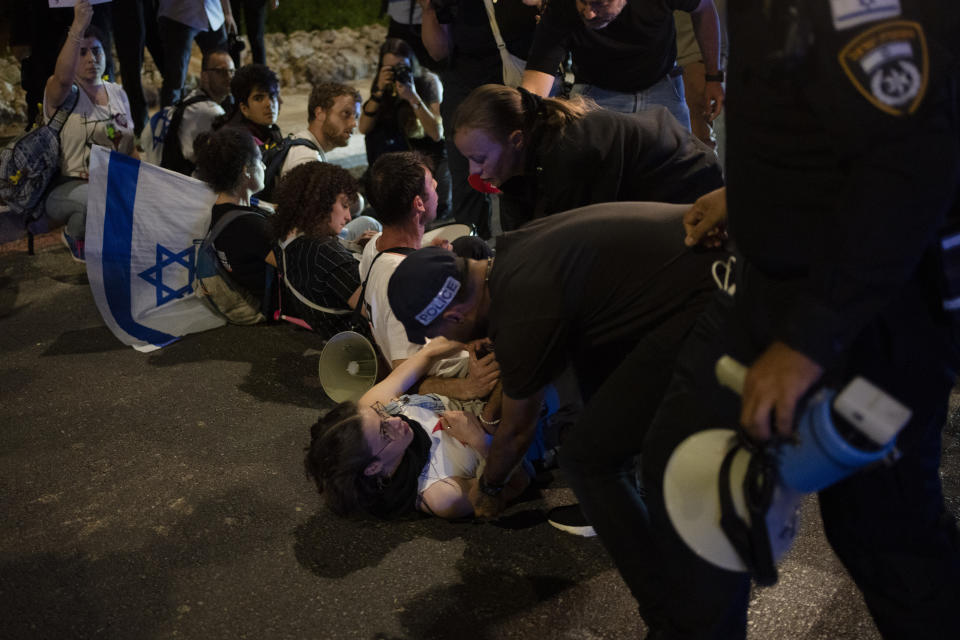 Police officers remove demonstrators who are trying to block a street during a protest against Israeli Prime Minister Benjamin Netanyahu's government and call for the release of hostages held in the Gaza Strip by the Hamas militant group near the Knesset, Israel's parliament, in Jerusalem, Monday, April 1, 2024. (AP Photo/Leo Correa)