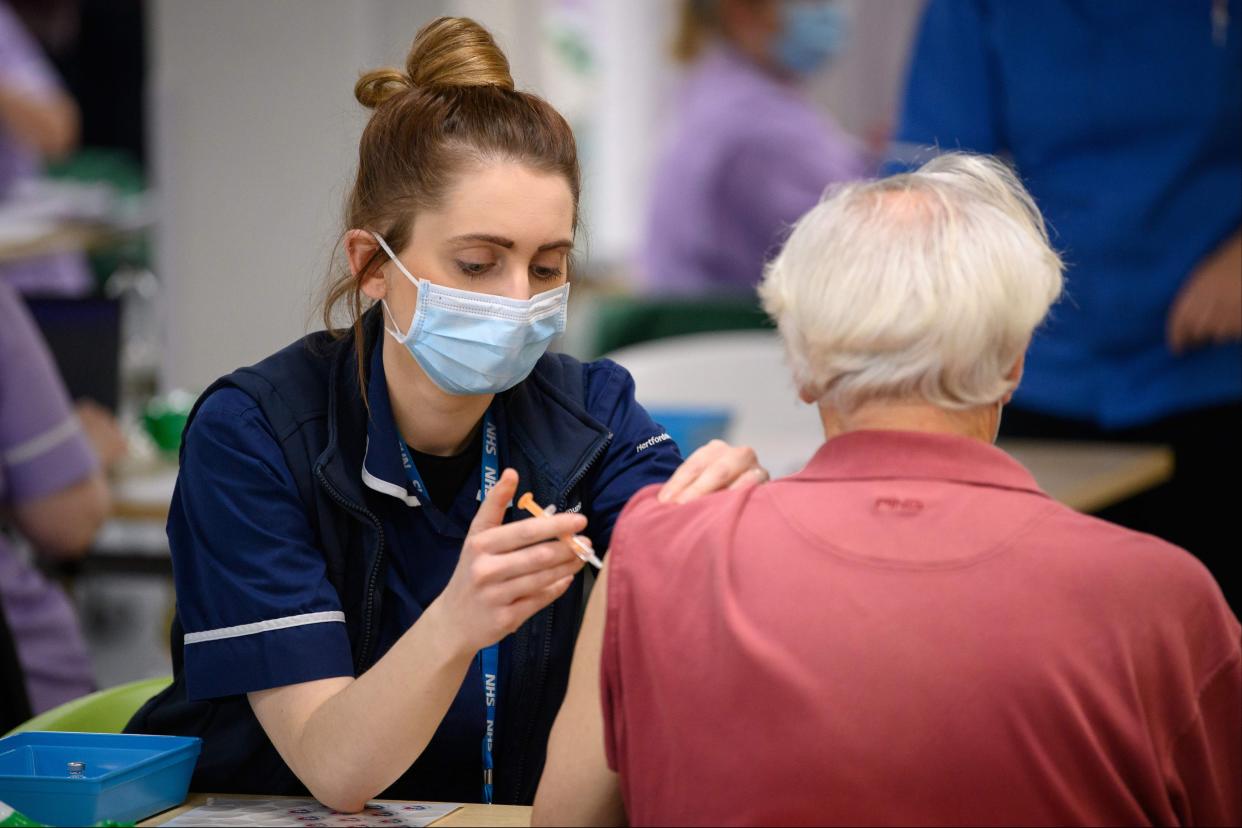 <p>A member of the medical team administers a coronavirus Covid-19 vaccine shot at the NHS vaccination centre in Robertson House in Stevenage</p> (AFP)