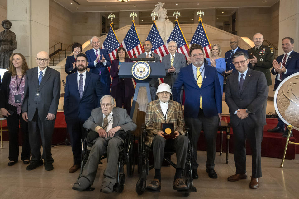 Ghost Army members John Christman, of Leesburg, N.J., second from left standing, Seymour Nussenbaum, of Monroe Township, N.J, in wheelchair at left, and Bernard Bluestein, of Hoffman Estates, Ill., in wheelchair at right, join military and congressional officials as members of their secretive WWII-era unit are presented with the Congressional Gold Medal during a ceremony on Capitol Hill, Thursday, March 21, 2024, in Washington. (AP Photo/Mark Schiefelbein)